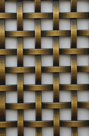 Close-up of a gold-toned woven lattice pattern formed by interlaced metal strips.